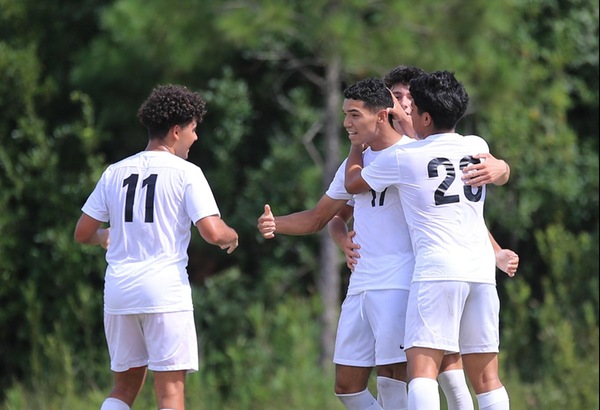 CFCC Men's Soccer teammates congradulate Alex Flores after a scored goal