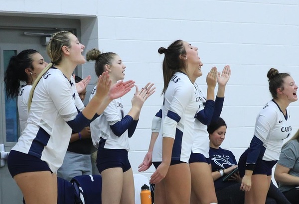 CFCC Volleyball players in a group cheering on the sideline